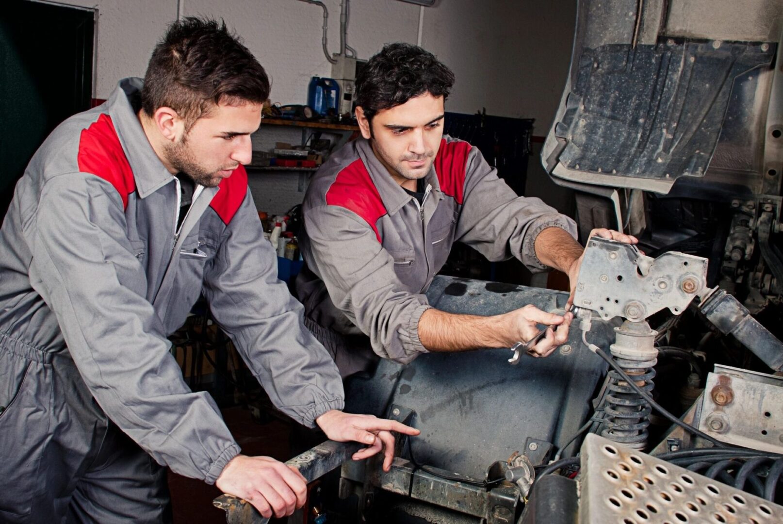 Two men working on a machine in a garage.