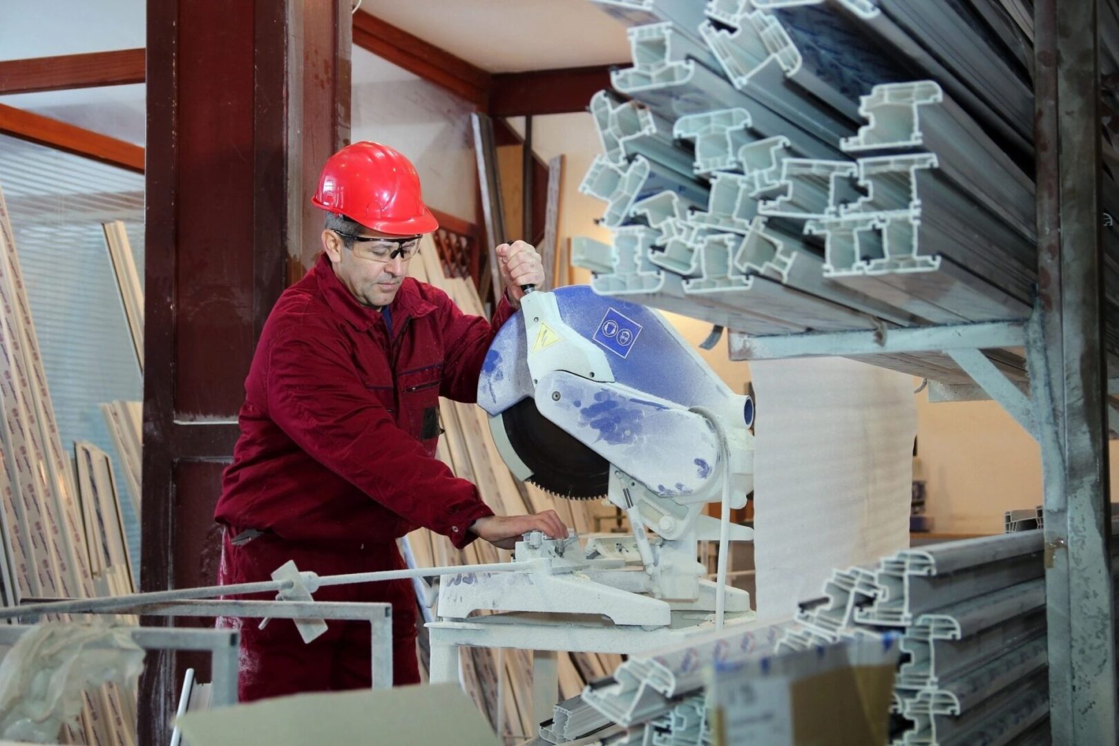 A man in red shirt and hard hat working on a machine.